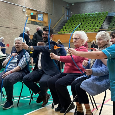 A group of older residents at the council's Chief Executive Mike Greene playing chair archery.